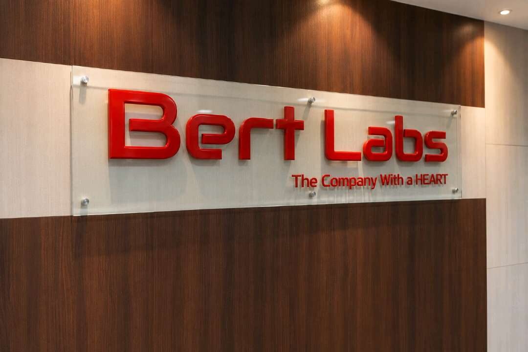 Office reception signage with red acrylic letters on a stand-off glass panel
