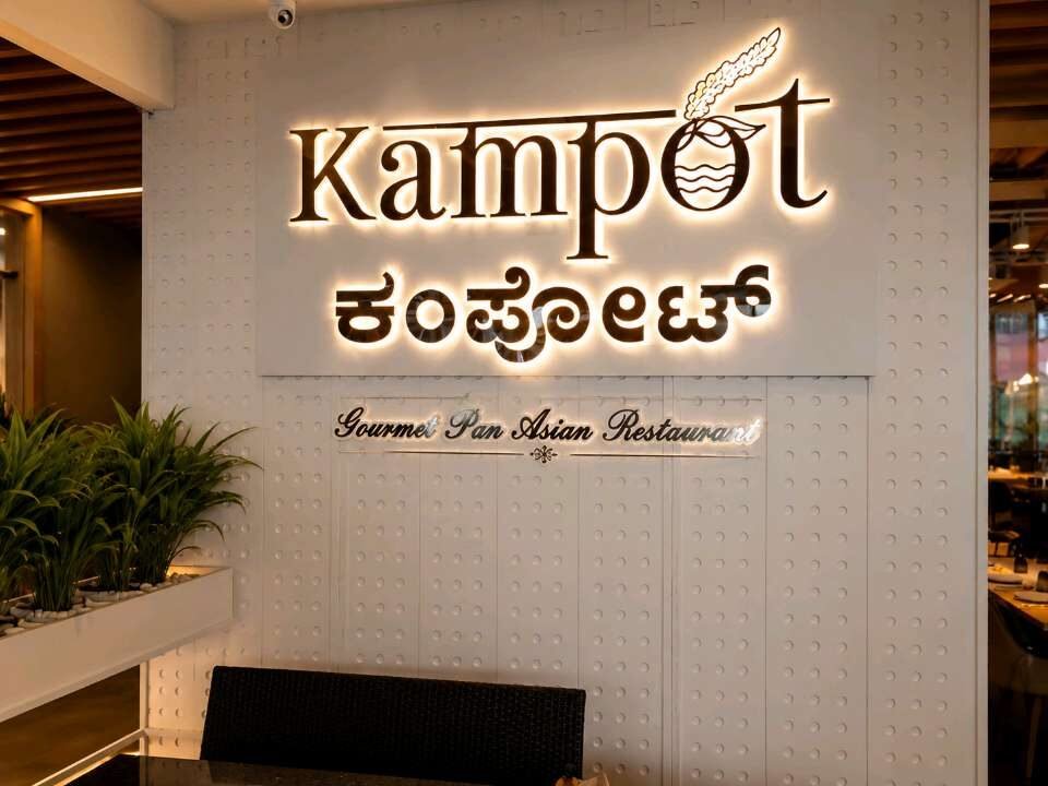 Backlit bilingual restaurant letters mounted on a textured interior wall