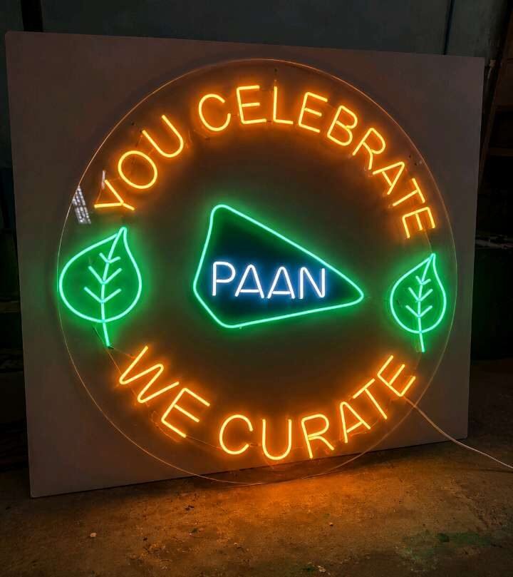 Circular neon-style LED sign with multi-colour lettering and graphics