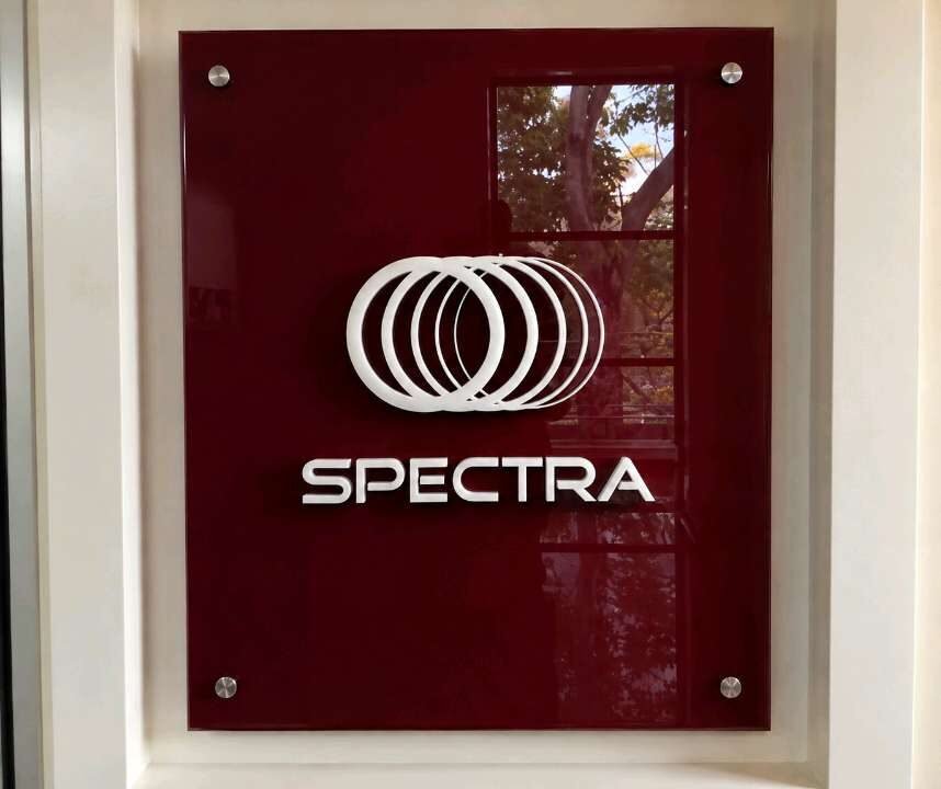 Acrylic wall signage panel with white logo and lettering in an interior lobby