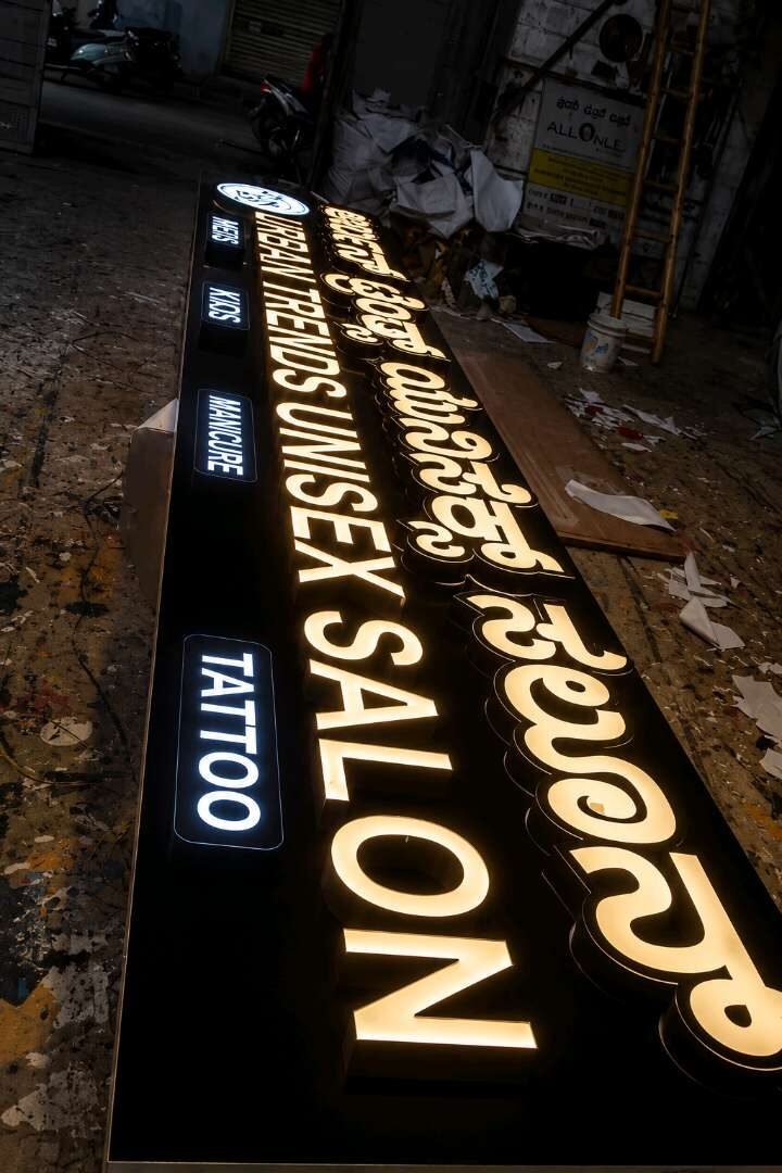 Backlit salon signboard with illuminated bilingual letters at night