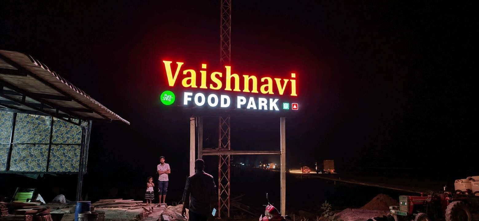 Illuminated high-level food park signage photographed at night